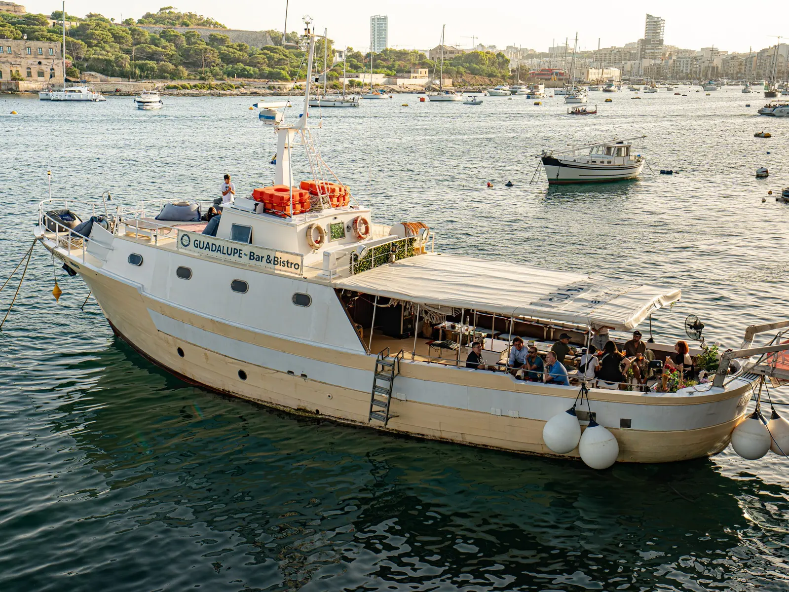 Guadalupe boat bar from the water with guests on deck